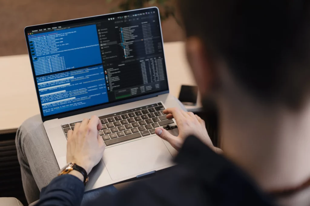 Un développeur utilisant un ordinateur portable pour écrire du code, avec un environnement de développement en ligne de commande où le langage Julia est utilisé pour la programmation et l'analyse de données.